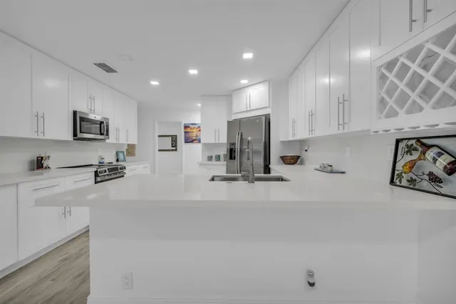 a kitchen with granite countertop white cabinets and white appliances