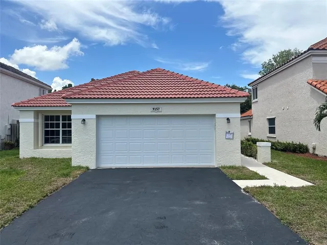a front view of a house with a yard and garage