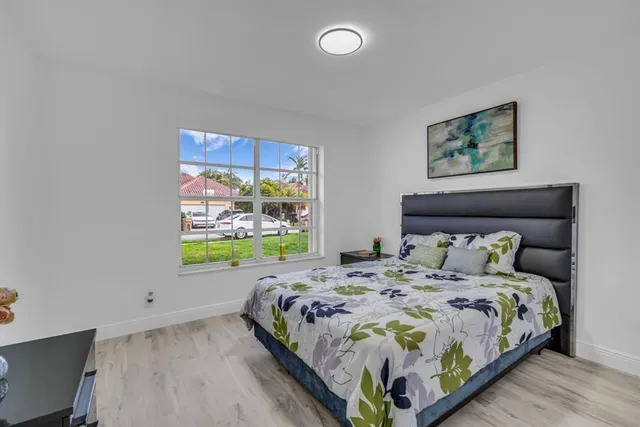 a bedroom with a bed and a dresser next to a window