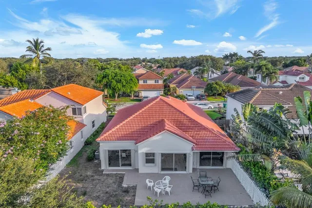 an aerial view of residential house with outdoor space and trees all around
