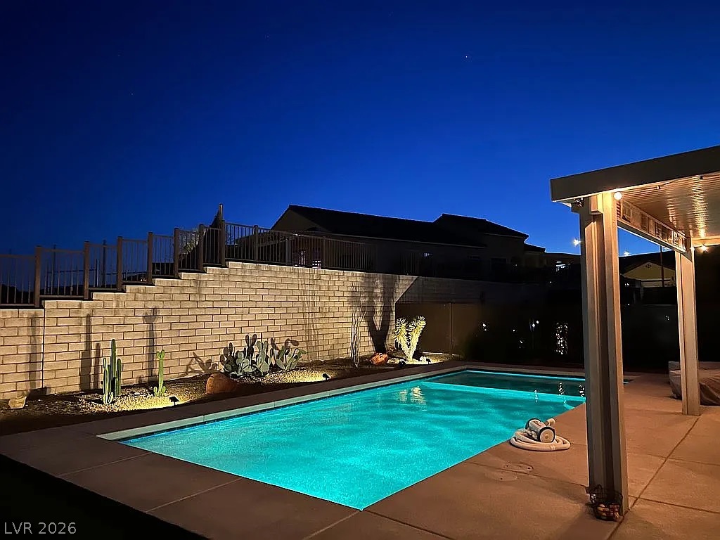 A private desert oasis with an inviting pool and covered patio for evening relaxation.
