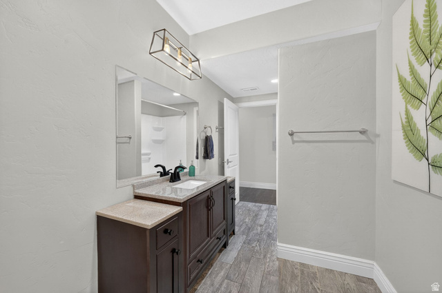 14738 Tangle Hill Road Herriman, UT 84096 - Photo 49 of 66 Dark wood-finish vanity with a light-toned countertop, undermount sink, and matte black faucet