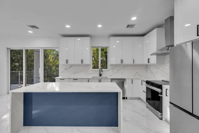 a kitchen with stainless steel appliances a sink stove and refrigerator