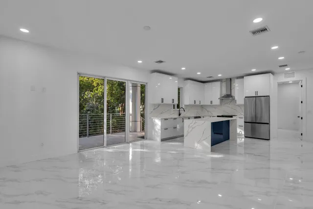 a view of kitchen with stainless steel appliances refrigerator oven and white cabinets