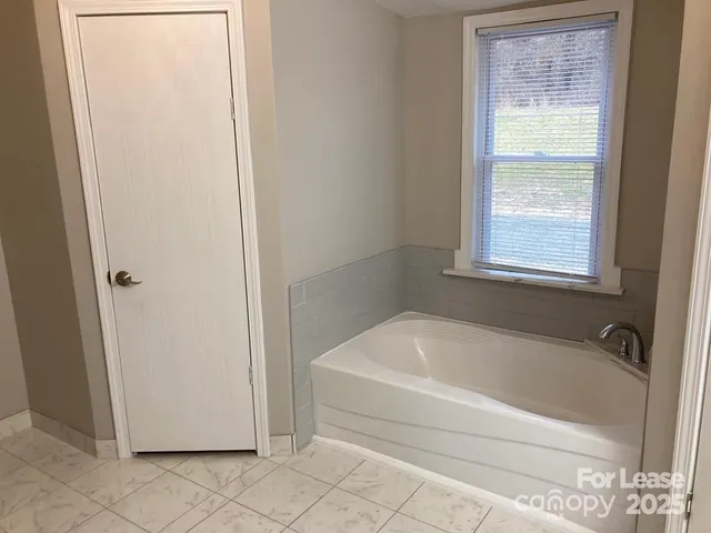 a white bath tub sitting next to a window
