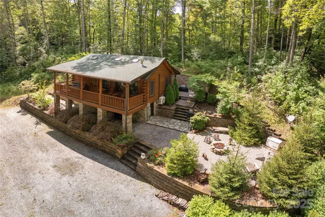 a view of a house with a yard and large trees