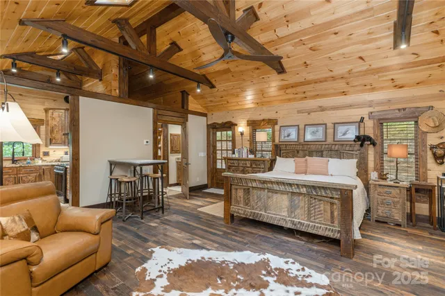 a bedroom with a bed a flat screen tv and a chandelier