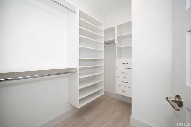 a view of walk in closet with empty racks