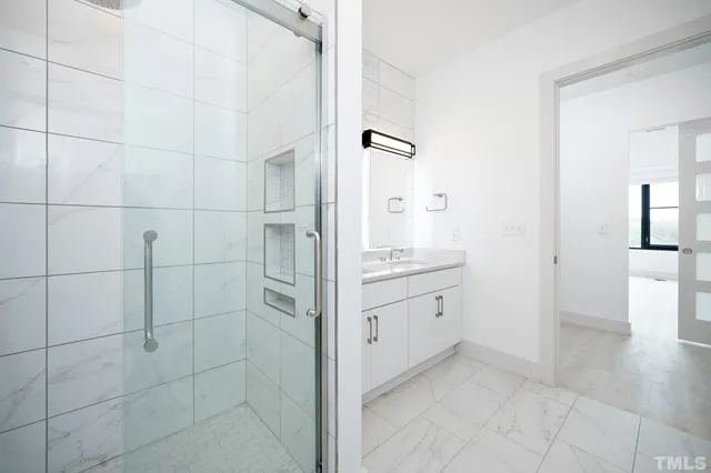 a bathroom with a granite countertop sink a mirror and a shower