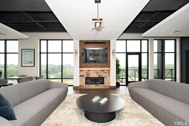 a living room with furniture fireplace and a large window