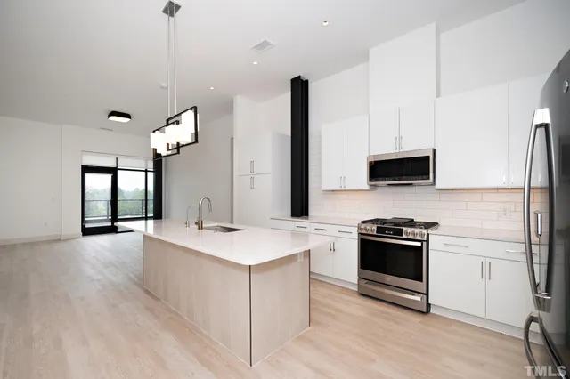 a kitchen with stainless steel appliances granite countertop a sink stove and refrigerator