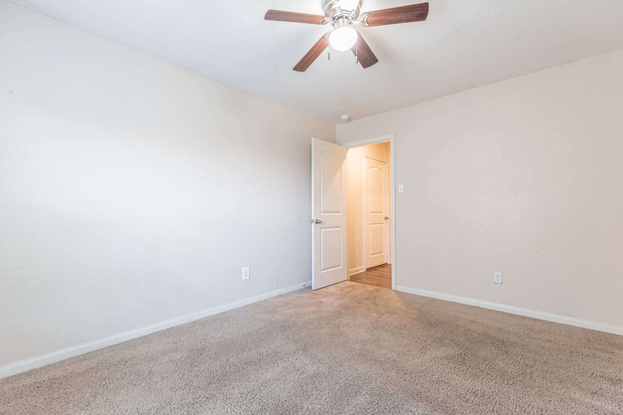 20017 Hubert R Humphrey Road Manor, TX 78653 - Photo 10 of 35 A spacious bedroom featuring comfortable carpet flooring and an overhead ceiling fan for optimal airflow.