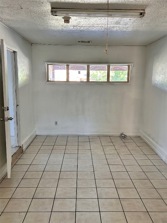 2305 South Bagdad Road Leander, TX 78641 - Photo 6 of 8 Spare room featuring light tile patterned flooring and a textured ceiling