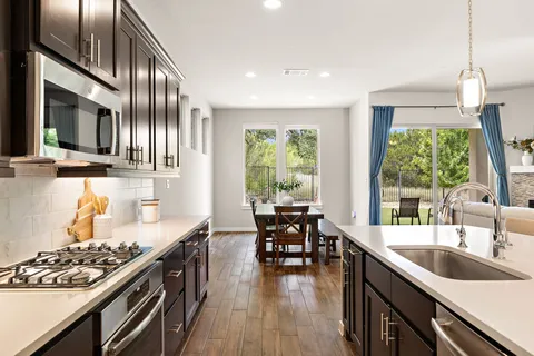 a kitchen with stainless steel appliances granite countertop a sink stove and cabinets