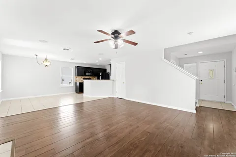 a view of a kitchen with wooden floor and a ceiling fan