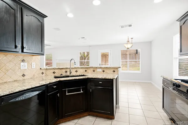 a kitchen with a sink a stove and cabinets