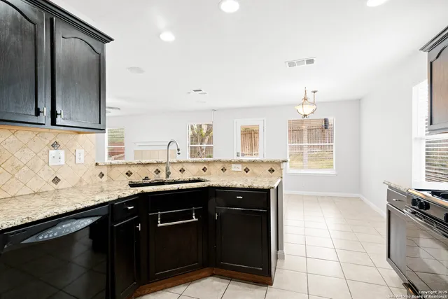a kitchen with a sink a stove and cabinets