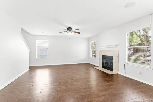 an empty room with windows fireplace and a sink