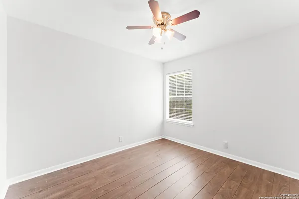 an empty room with wooden floor and window
