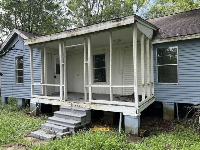 a view of house with a yard and sitting area