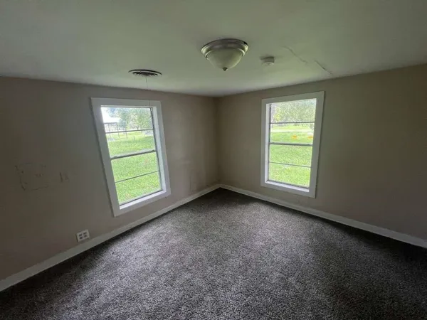 an empty room with a window and a ceiling fan