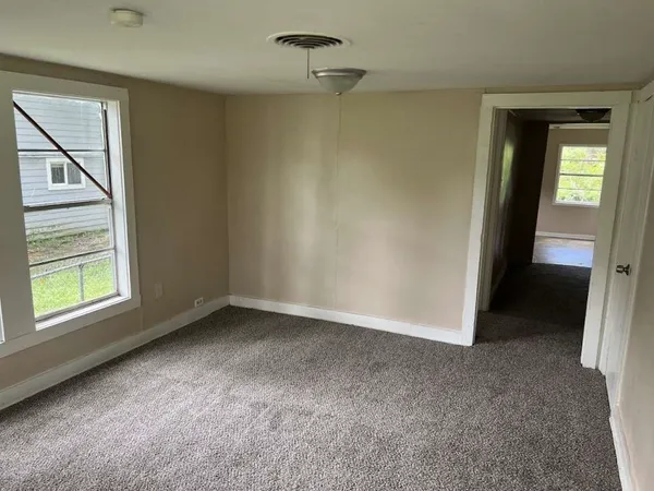 an empty room with windows and closet