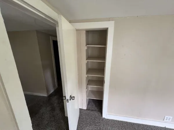a view of walk in closet with empty racks