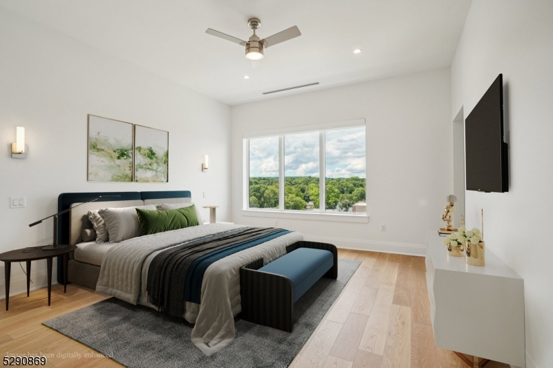620 Bloomfield Avenue, Unit PHD Bloomfield, NJ 07003 - Photo 12 of 24 a bedroom with a large bed and a flat tv screen on dresser