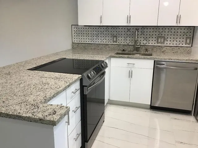 a kitchen with granite countertop cabinets and window