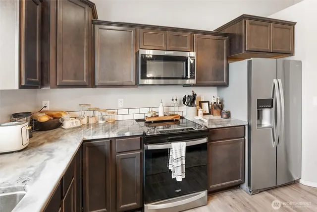 a kitchen with granite countertop a sink stove and refrigerator