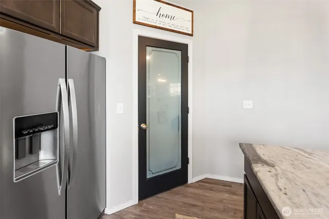 a view of a kitchen with a refrigerator and wooden floor