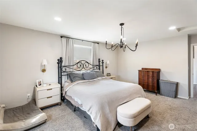a bedroom with a bed a chandelier and couch