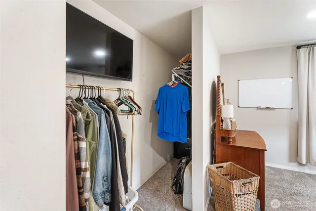 a view of walk in closet with clothes and shoes