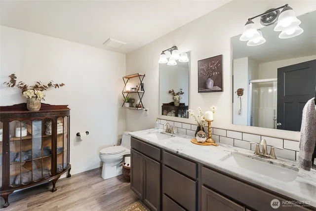 a bathroom with a granite countertop sink a toilet and a mirror