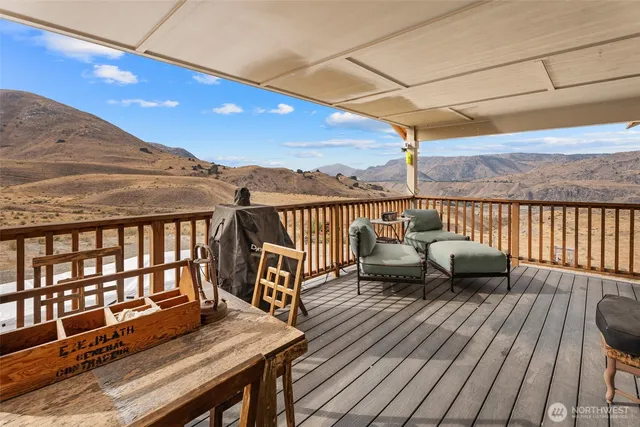 a view of a balcony with wooden floor and outdoor seating
