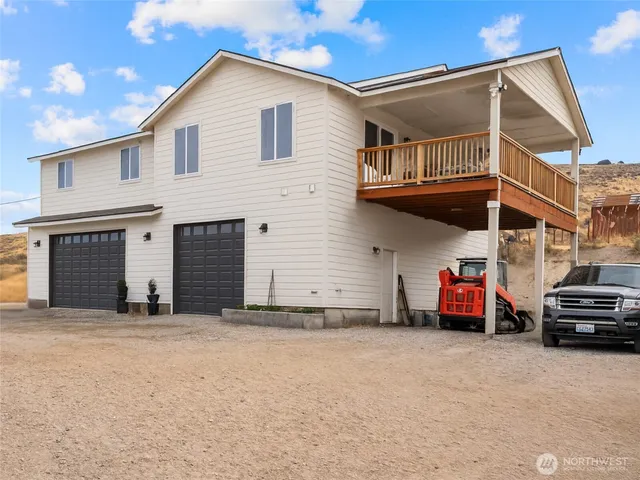 a view of a house with a barbeque and large trees