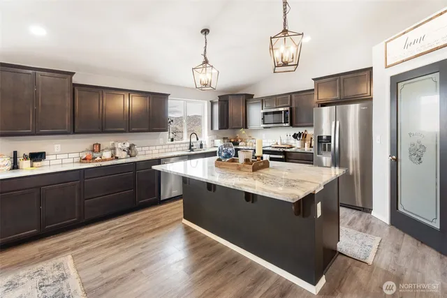 a kitchen with granite countertop stainless steel appliances and wooden cabinets