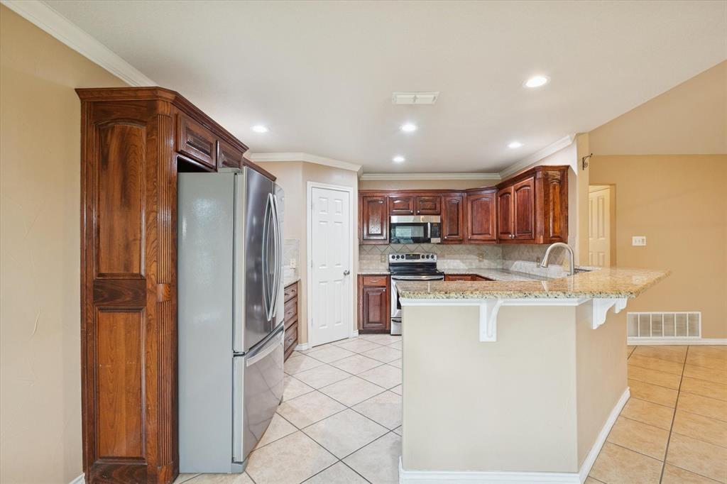 548 Highland Road Springtown, TX 76082 - Photo 14 of 40 a kitchen with stainless steel appliances granite countertop a refrigerator and a stove top oven