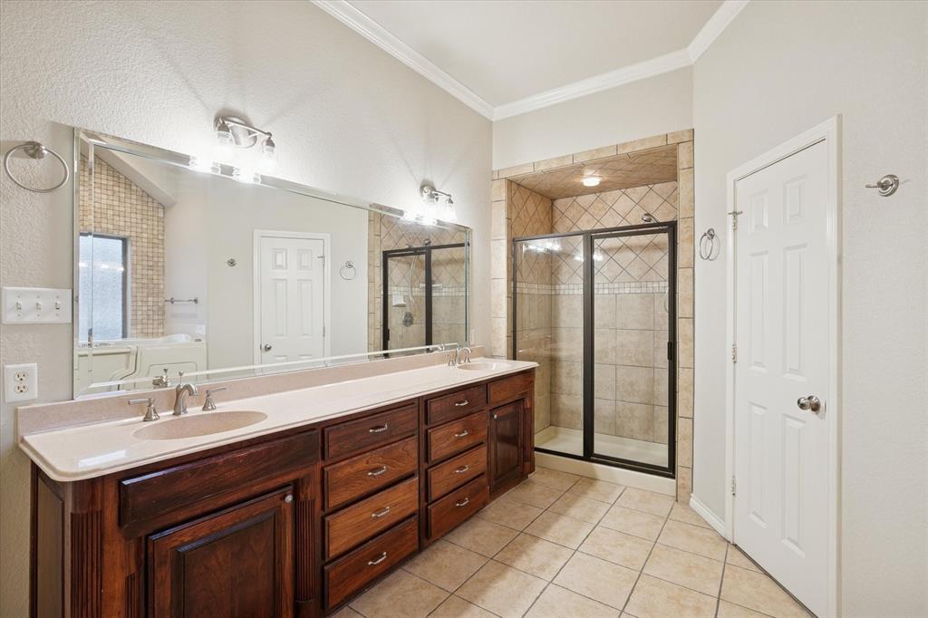548 Highland Road Springtown, TX 76082 - Photo 22 of 40 a bathroom with a double vanity sink a mirror and a shower