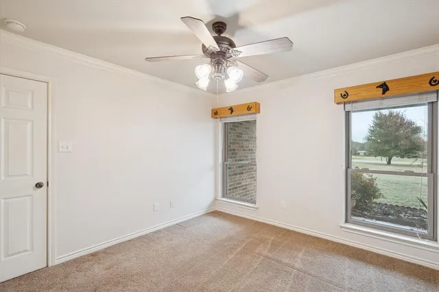an empty room with window and ceiling fan