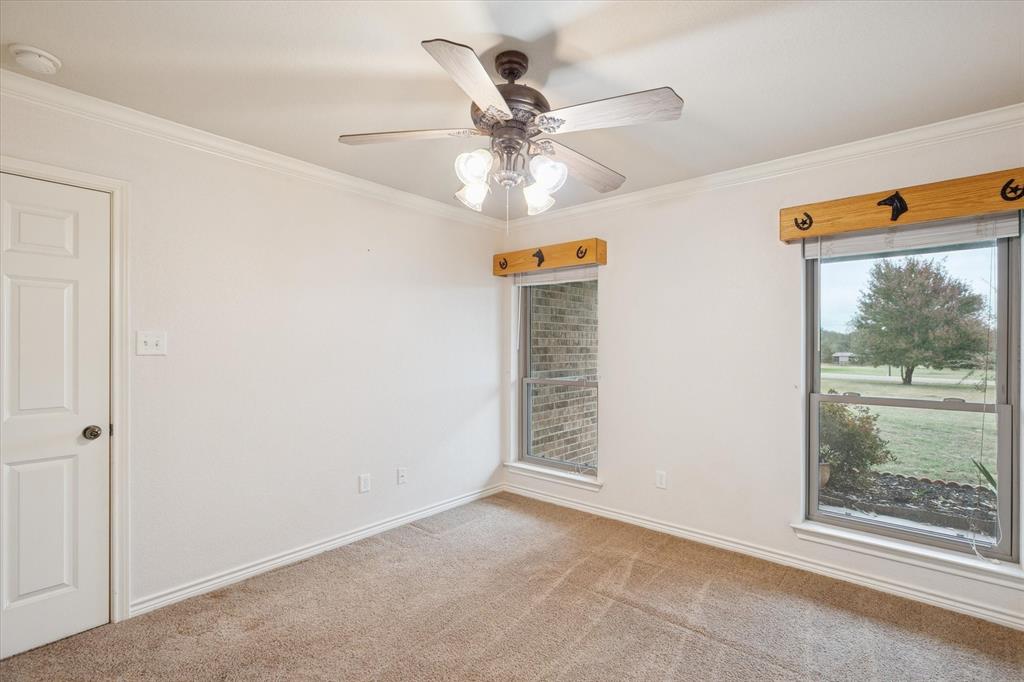 548 Highland Road Springtown, TX 76082 - Photo 25 of 40 an empty room with window and ceiling fan