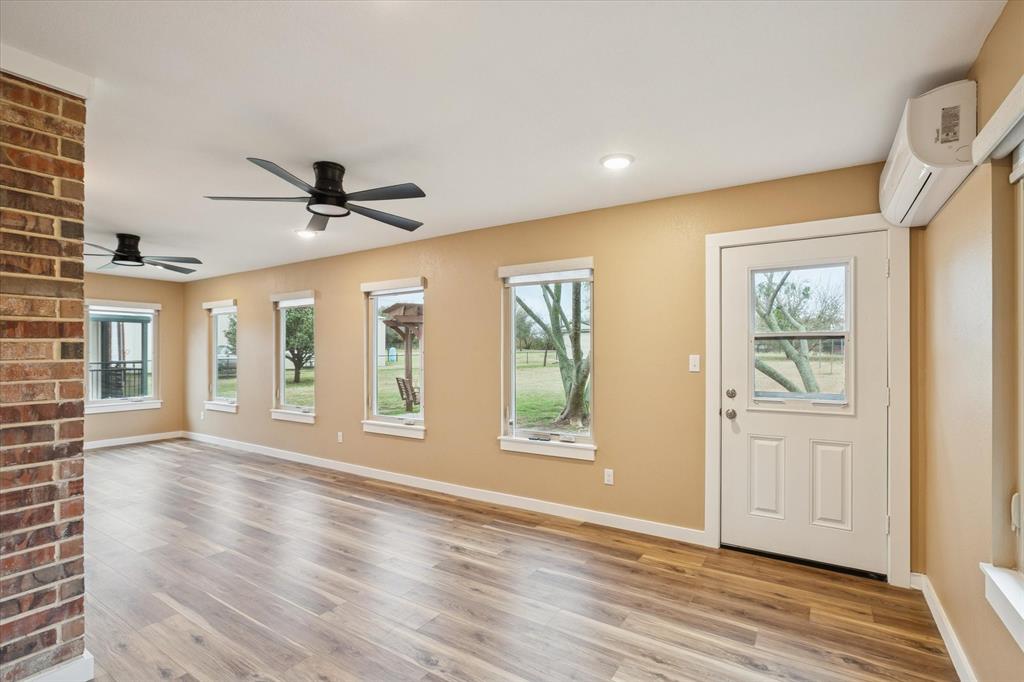 548 Highland Road Springtown, TX 76082 - Photo 30 of 40 a view of an empty room with a window and wooden floor