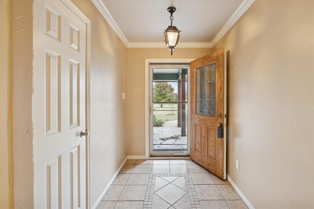 548 Highland Road Springtown, TX 76082 - Photo 5 of 40 a view of a hallway with wooden floor and a livingroom