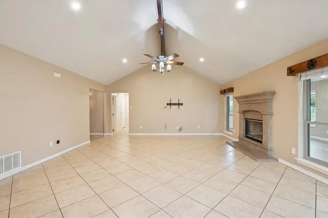 a view of an empty room with a fireplace and a window