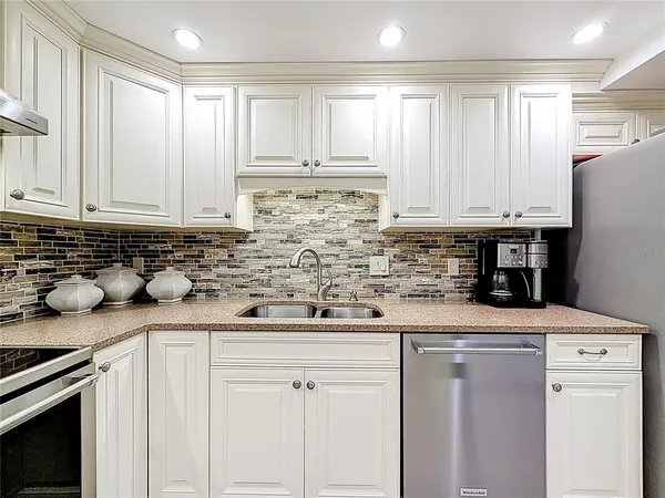 a kitchen with stainless steel appliances granite countertop a refrigerator and a stove top oven