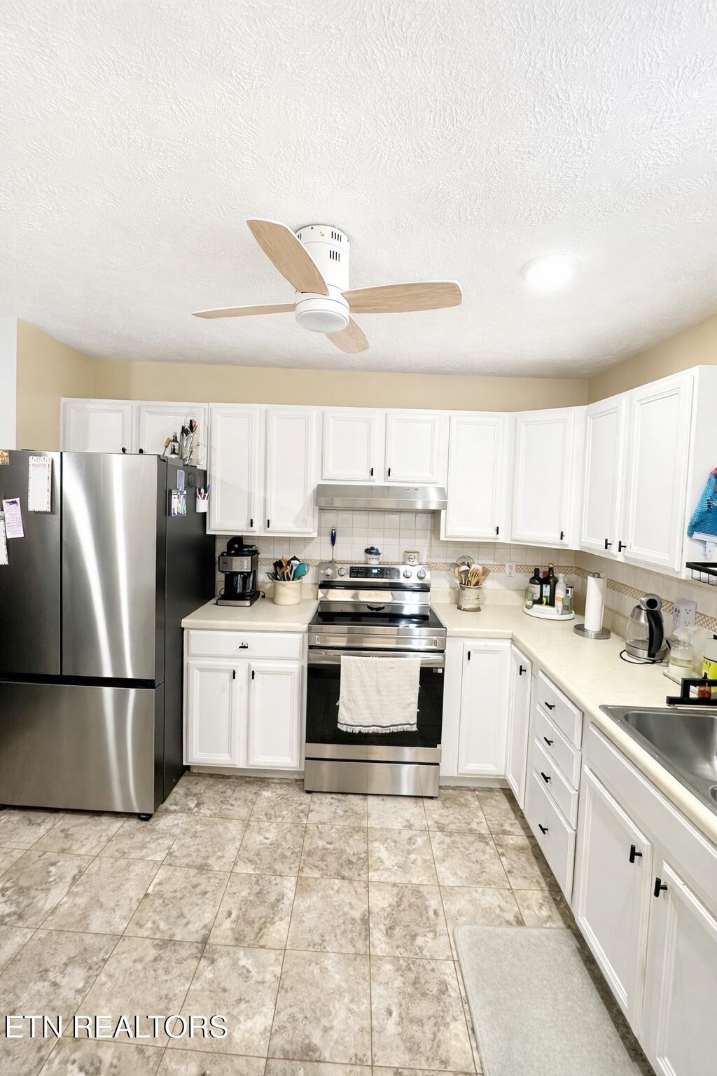 15 Rena Circle Crossville, TN 38572 - Photo 9 of 14 a kitchen with granite countertop a refrigerator oven a sink and white cabinets