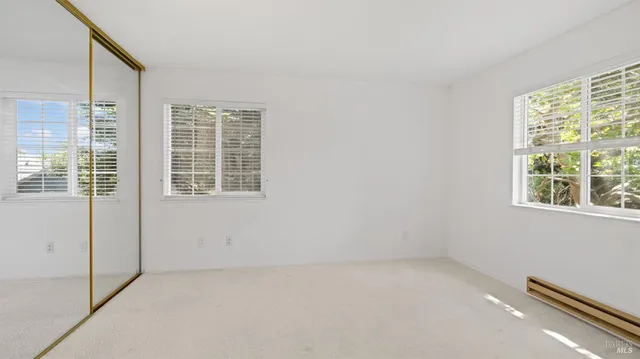 a view of an empty room with window and cabinet