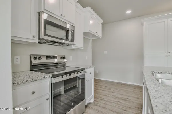 a kitchen with stainless steel appliances a stove microwave and sink