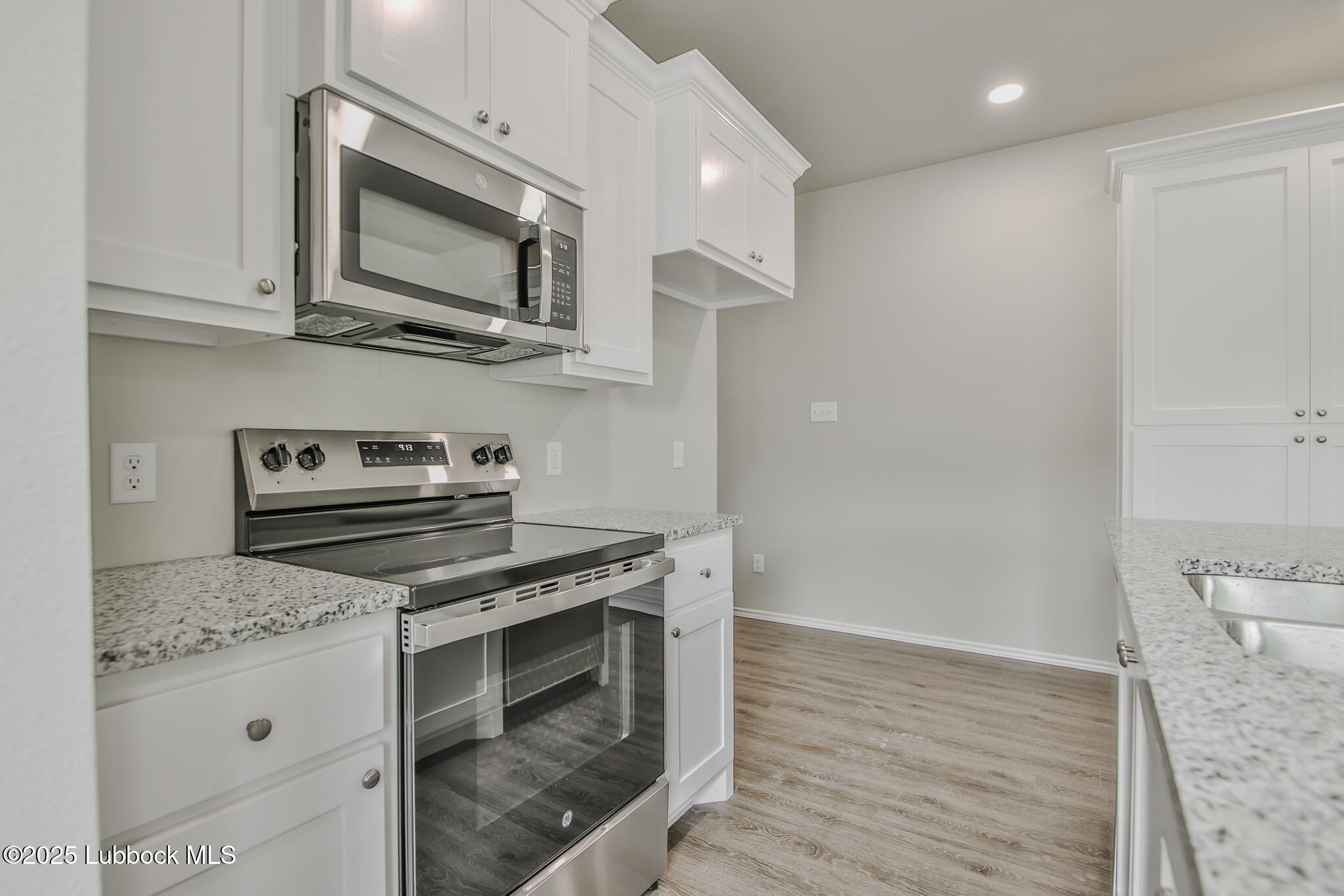 3119 74th Street Lubbock, TX 79423 - Photo 14 of 36 a kitchen with stainless steel appliances a stove microwave and sink