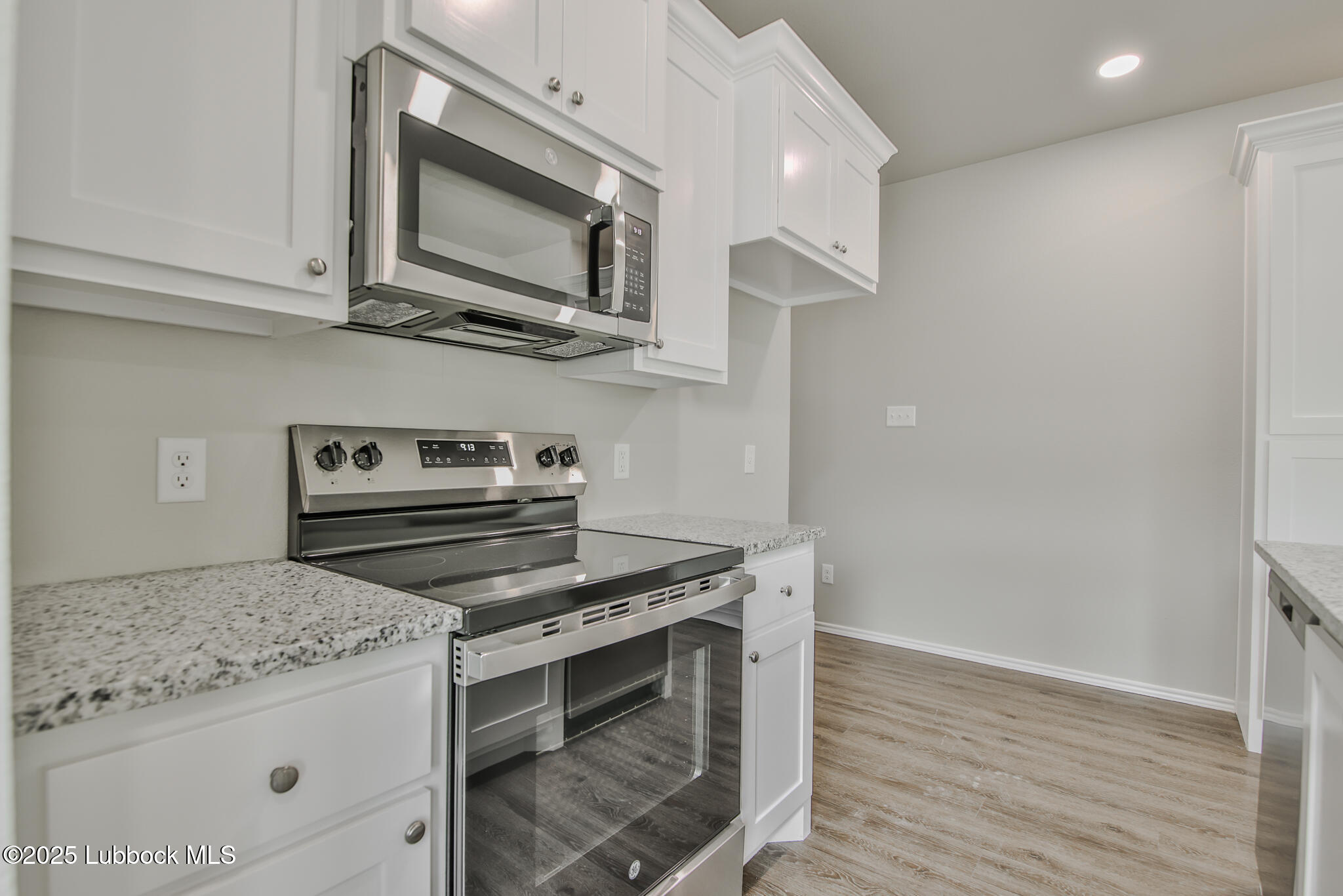 3119 74th Street Lubbock, TX 79423 - Photo 15 of 36 a kitchen with stainless steel appliances granite countertop a stove and a microwave